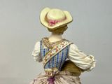 a figurine of a woman in a dress and hat