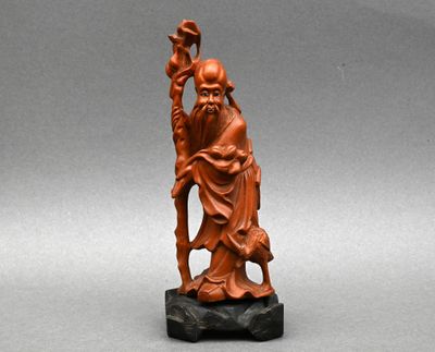 une ancienne figurine chinoise sculptée représentant un homme tenant un bâton