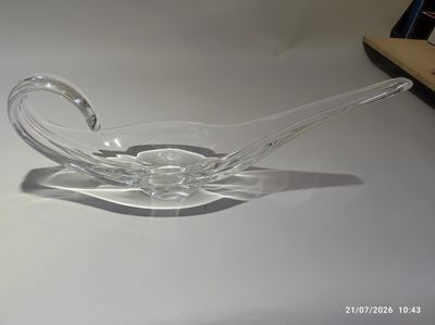 un bol en verre transparent muni d'une anse incurvée, posé sur une table