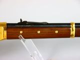 the rifle is made of wood and has a brass - plated handle
