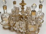 many glass bottles and glasses on a gold stand