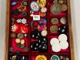 une boîte en bois remplie d'un assortiment de boutons et de broches