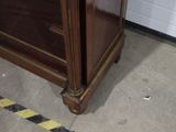 a wooden cabinet with a black and white striped line on the floor