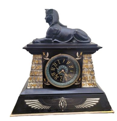 une statue de sphinx au sommet d'une horloge