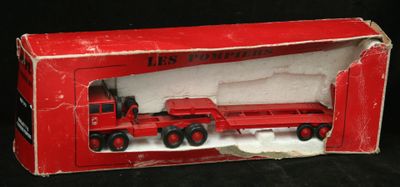 un camion jouet rouge dans une boîte rouge sur fond noir