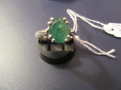 une bague sertie d'une pierre verte, posée sur une table