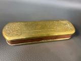 gold plated box on a leather surface with a brown handle