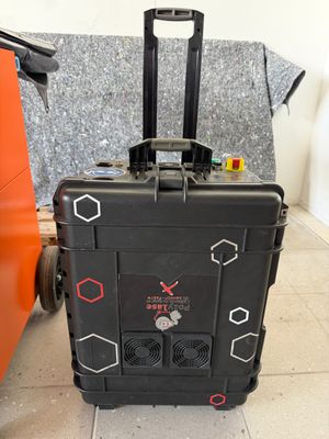 a piece of luggage sitting on the floor next to an orange suitcase