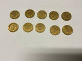 a bunch of gold coins sitting on top of a white table