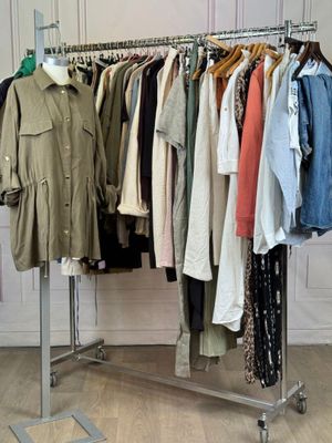 a lot of clothes hanging on a rack in a room