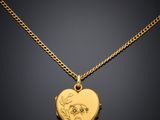a gold locke with a heart shaped locke on a chain