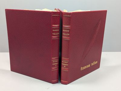 deux livres rouges posés sur une table blanche