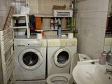une machine à laver et des toilettes dans une petite salle de bains