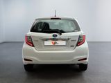 the back end of a white toyota yaris parked in a room