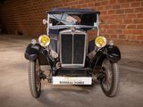 a old car that is parked in front of a brick wall