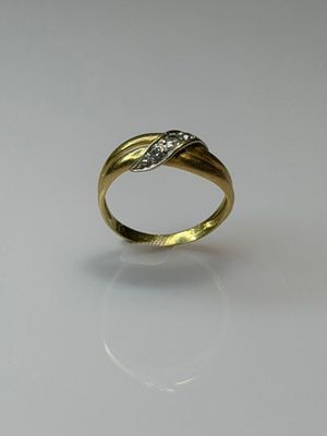 a close up of a gold ring with diamonds on a white surface
