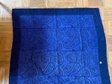 an image of a blue and black blanket on a wooden floor