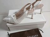 the white shoes are on the box next to the bag