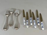 cinq fourchettes, un couteau, une cuillère et un repose-cuillère posés sur une table