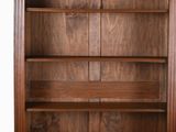 a wooden bookcase with two doors and a shelf