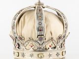 une vieille couronne surmontée d'une croix, posée sur un fond blanc