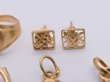 a lot of gold rings and earrings on a white surface