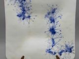 un gros plan d'une assiette bleue et blanche posée sur un socle