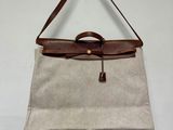 un sac à main beige et marron accroché au mur