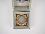 a close up of a ring in a box on a white surface