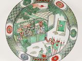a plate with a picture of people in a garden