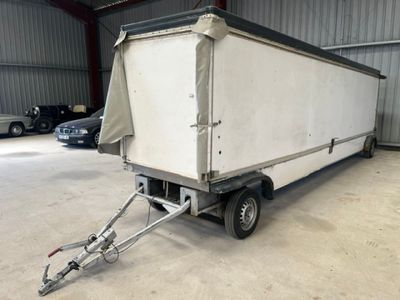 une remorque à laquelle est attelée une autre remorque, dans un garage