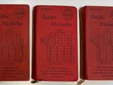 three red books sitting on top of a table next to each other