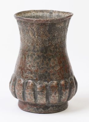 un vase brun posé sur une surface blanche