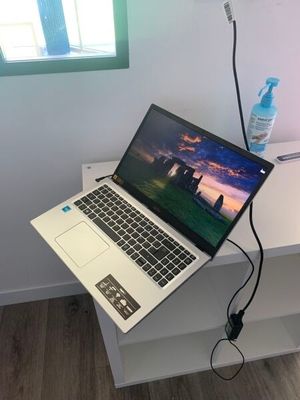 un ordinateur portable posé sur un bureau, à côté d'une bouteille d'eau