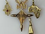 three gold and silver jewelry pieces are displayed on a white surface