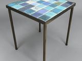 une petite table avec un plateau en carrelage bleu et des pieds en bois