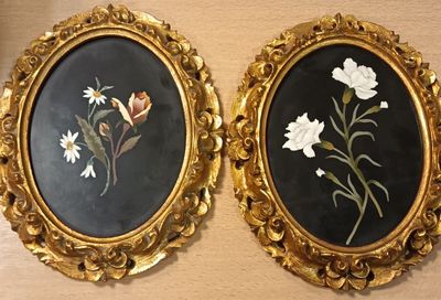 Deux tableaux représentant des fleurs, encadrés, sont accrochés côte à côte sur un mur.