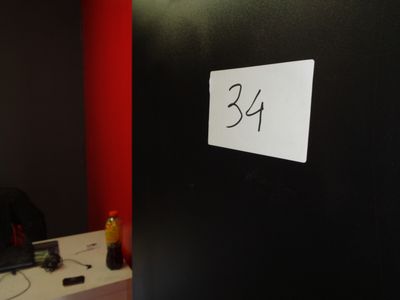 une photo d'une pièce avec un mur noir et une pancarte blanche accrochée au mur