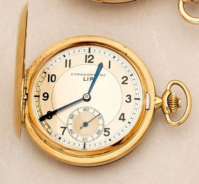 a close up of a gold pocket watch with a chain