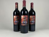 three bottles of red wine sitting next to each other on a table