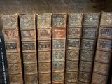 de nombreux livres anciens rangés sur une étagère dans une bibliothèque
