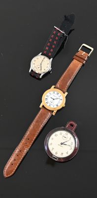 three different watches on a black surface with a watch in the foreground
