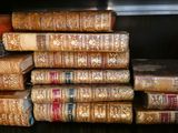 plusieurs vieux livres empilés les uns sur les autres sur une étagère