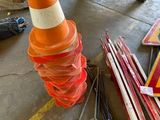 orange and white traffic cone sitting next to a pile of construction materials