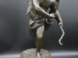 a bronze statue of a cupid holding a snake on a marble base