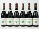 six bouteilles de vin sont alignées sur une table