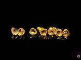 a close up of a group of yellow diamonds on a black surface