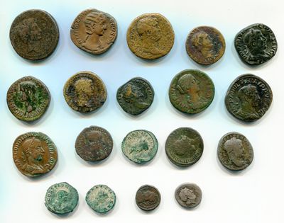 Un assortiment de pièces de monnaie romaines antiques est présenté sur un support blanc