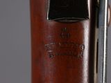 a close up of a rifle with a wooden body and a metal handle