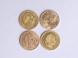 four different british coins sitting on top of a white surface